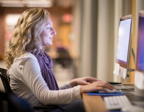 UNH Graduate Student using a computer