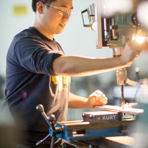 UNH student working with machinery