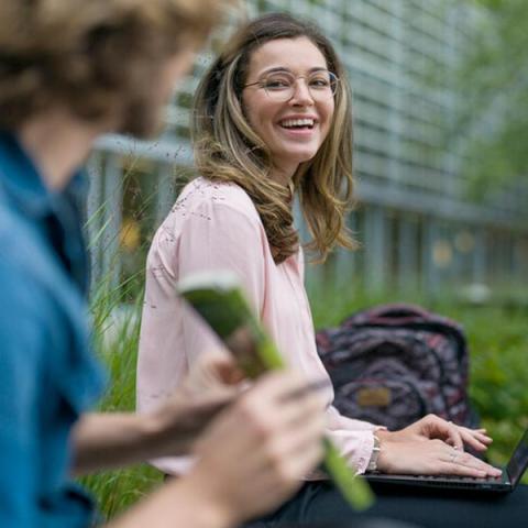 UNH graduate business professional sitting outside on bench