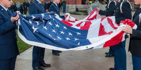 members of the military holding an American flag