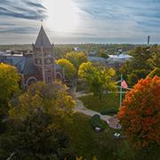 Campus overhead in the fall with bright sun peeking through the clouds
