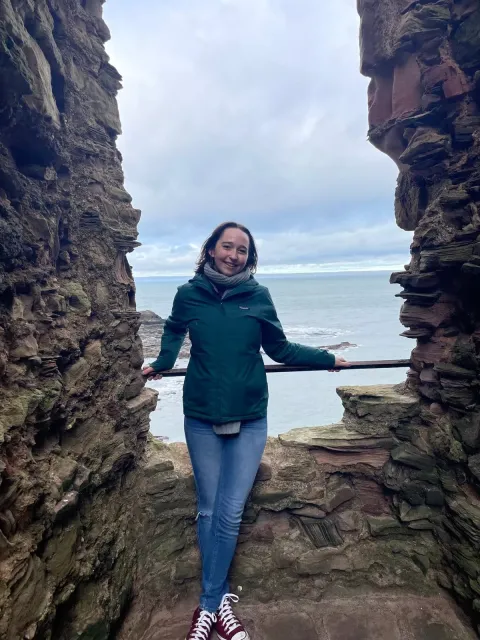UNH biology student Carrie Hill stands at a railing by the sea