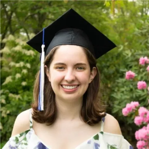 UNH genetics doctoral student Olivia Williams poses in her graduation cap