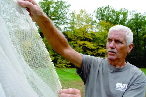 Chip Donnelly, operator of Stark Farm, setting up a net covering for his blueberry plants
