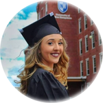 GCHS alum Maria Deneault posing at UNH Manchester in her cap and gown
