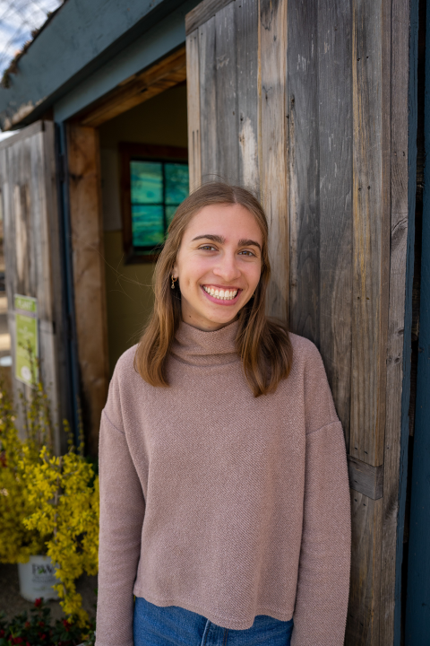 person standing outside by a wooden building