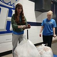 two students weighing trash