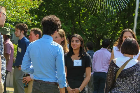 group of people standing outside talking with one another