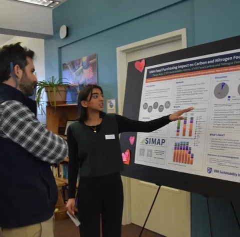 student presenting their research poster