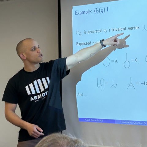 Person standing and pointing to a whiteboard with text on it