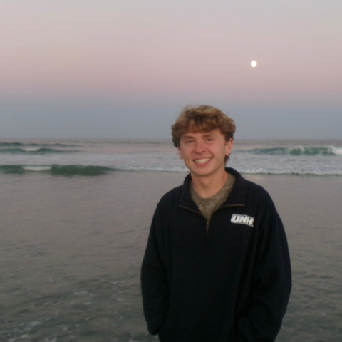 person standing on the beach at sunrise