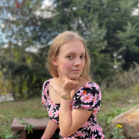 person sitting outside with trees in the background