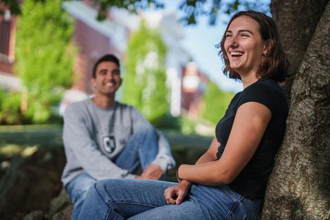 Two students sit outside of Hamilton Smith Hall