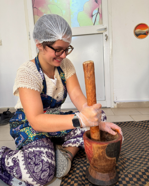 a person kneeling inside and stirring a pot
