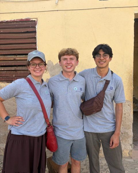 three people stand side by side outside 