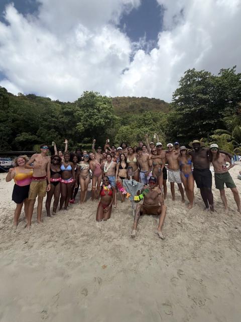 Landon Sprague poses with a large group of Lovango Resort & Beach Club coworkers on a beach in the U.S. Virgin Islands.