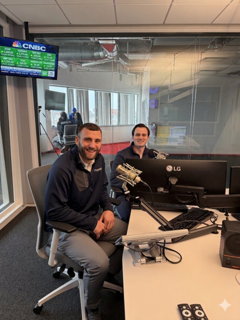 Kyle Hurley and Jon Coughlin sit at microphones while recording The Retirement Playbook podcast.