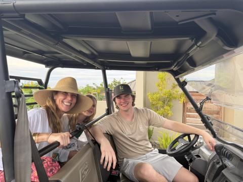 Landon Sprague sits behind the wheel of a utility vehicle with two resort guests during his internship at Lovango Resort & Beach Club.