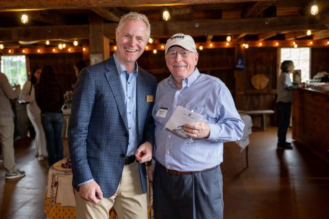 Dean Anthony S. Davis and a UNH alum pose inside a barn