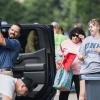 Adults help students unload their belongings from a car during move-in days