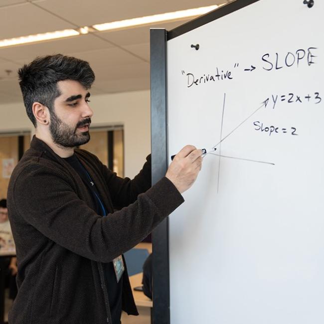 student writing on a whiteboard