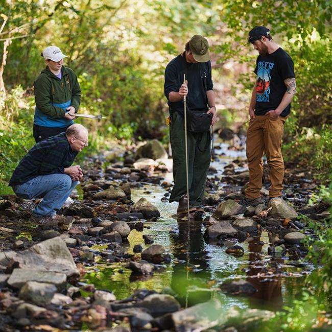 students testing sample in creek