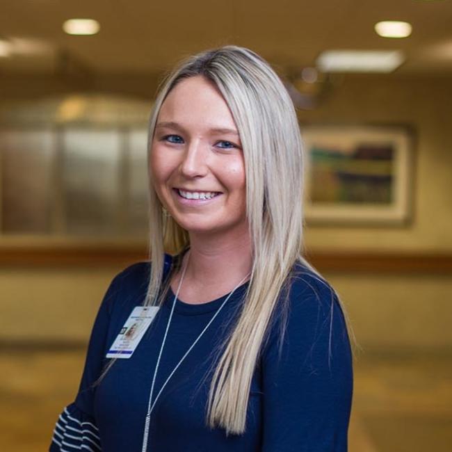 Female student in blue shirt smiling at the camera