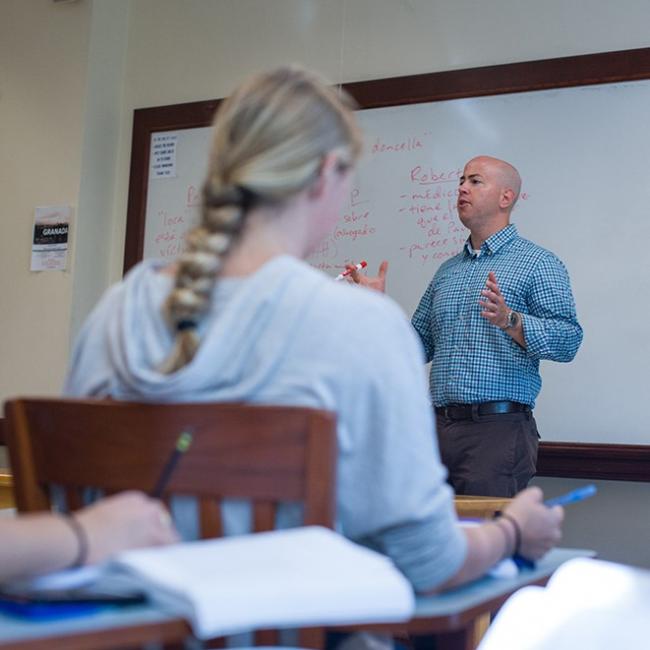 Male professor in blue shirt teaching a class