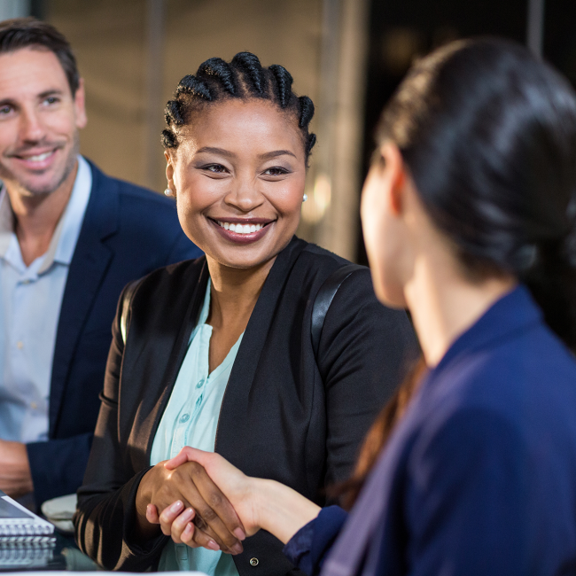 business woman shaking another woman's hand