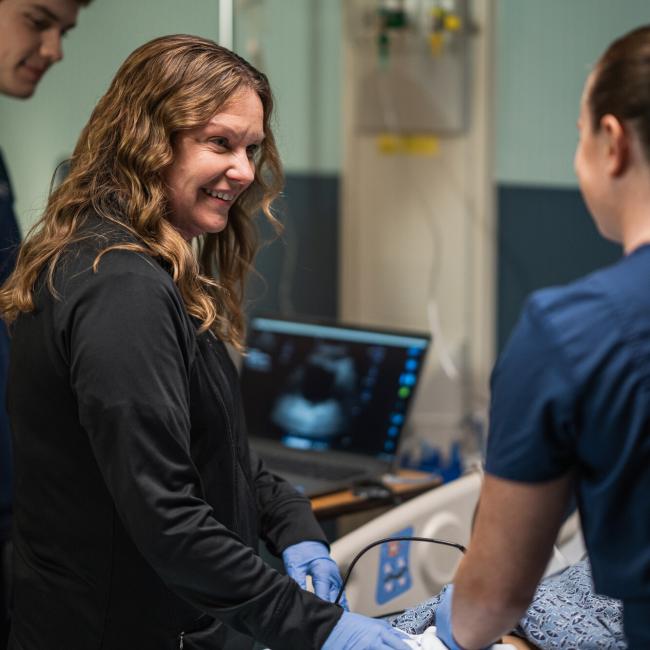 UNH nursing student working with a patient