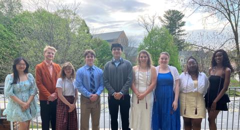 10 students, nicely dressed, outside on a balcony