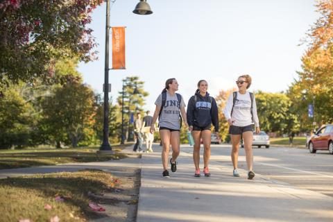 Students walking across the UNH campus on a sunny day