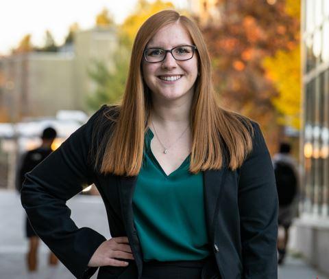 Student in professional attire outside during fall