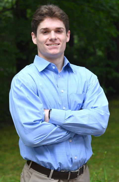 McNair scholar, professionally dressed, smiling, male, wooded backdrop