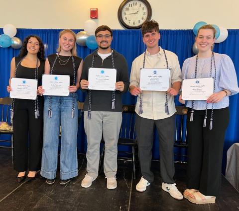 group of first-gen students serving as honor society officers holding their certificates of membership