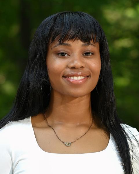 woman smiling, trees in background