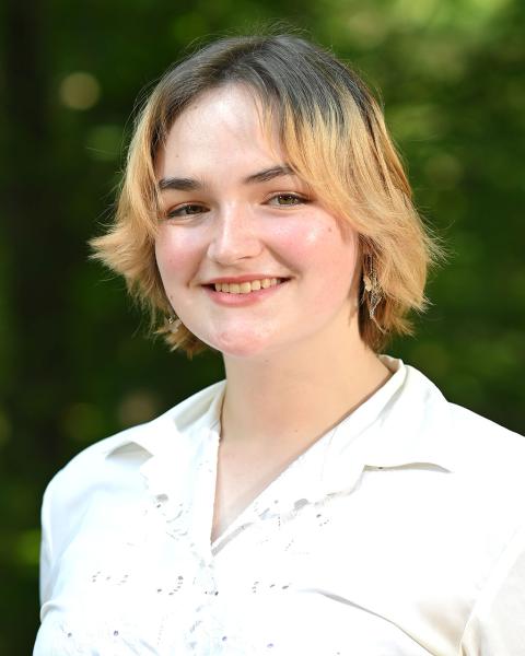 person in white collared shirt standing outside