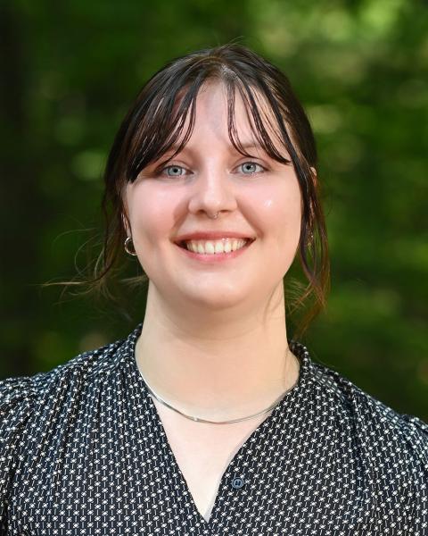 Person smiling, outside, professionally dressed