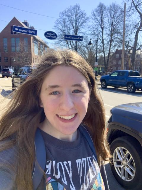 a white woman smiling with light brown straight hair