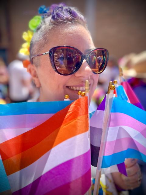 a woman in sunglasses with lesbian pride flag 