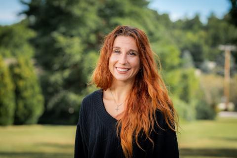 a white woman smiling with wavy red hair