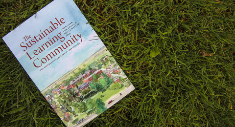 The Sustainable Learning Community book on the grass