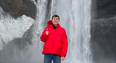 Brett standing in front of a snowy waterfall