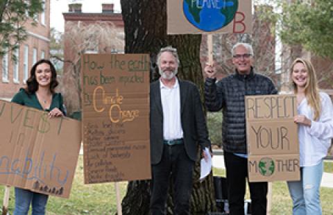 students and staff holding signs