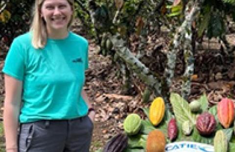Brockmann outside next to table of cocoa pods