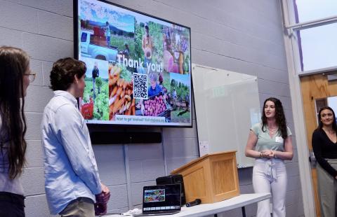 students presenting in front of a screen