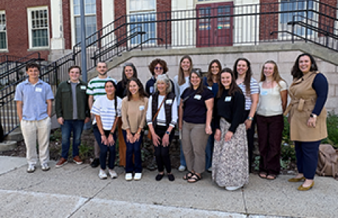 group of people standing together outside in front of a building