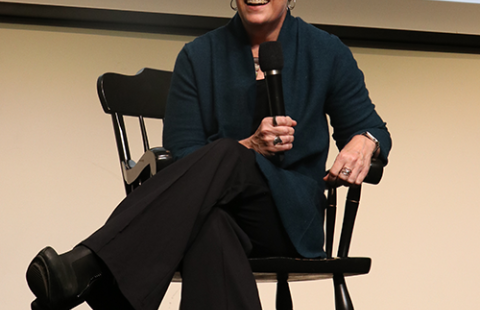 person sitting in a chair talking into a microphone