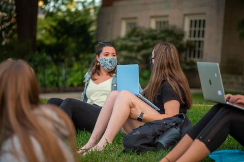 students sitting on the lawn socializing distanced