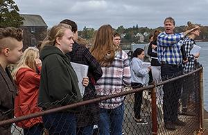 man instructing students outside at harbor